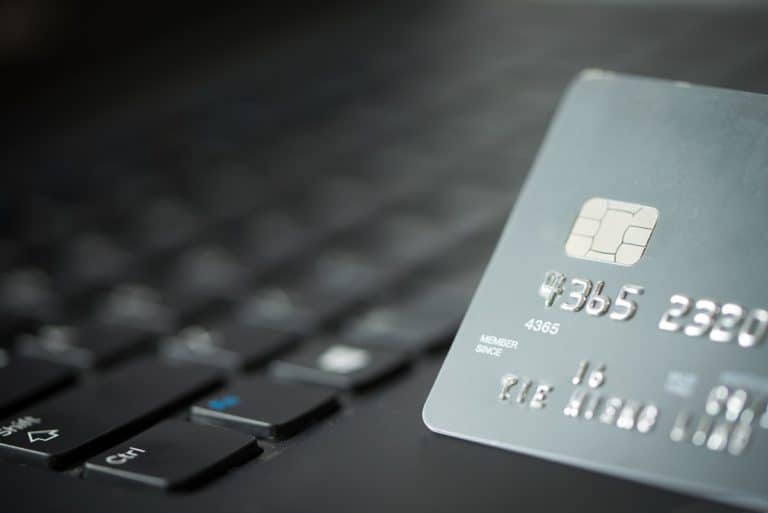 close up of credit card in front of laptop keyboard