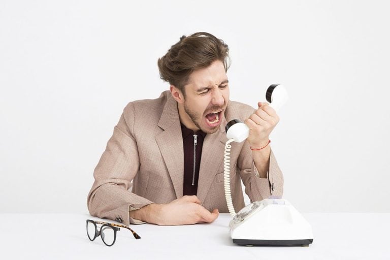businessman screaming into old telephone