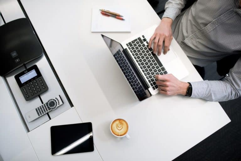 man sitting at desk working on laptop