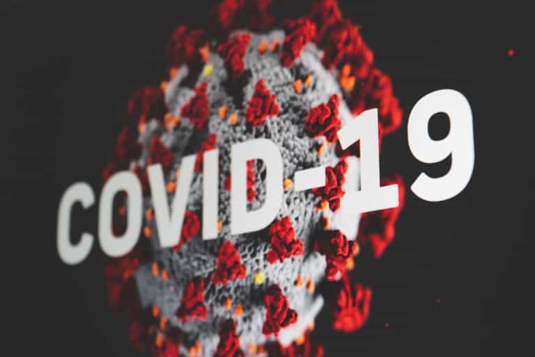 COVID-10 wording in front of an image of a virus