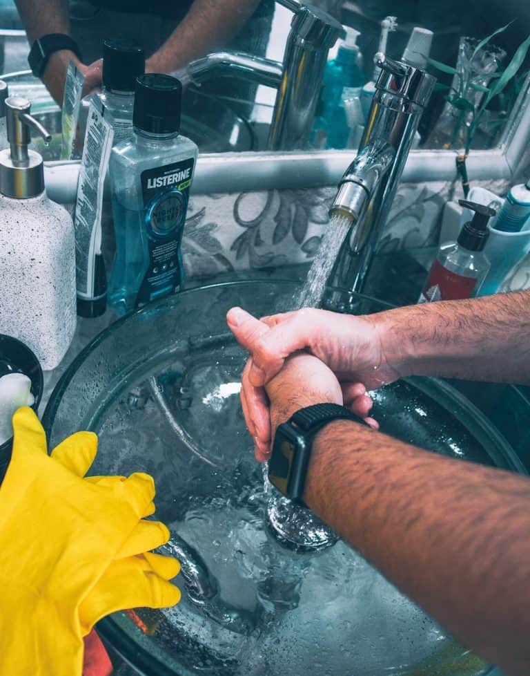 Man with apple watch washing hands in sink