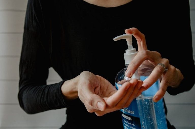women applying hand sanitizer to her hands
