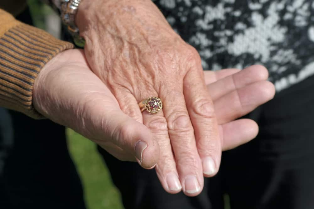 close up shot of an elderly couple holding hands