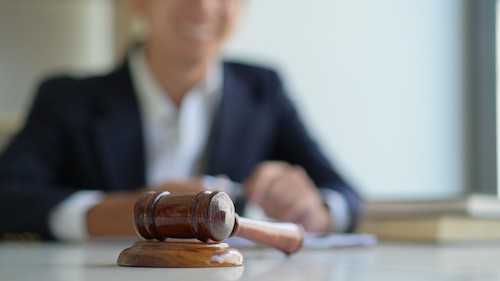 portrait of judges gavel with man blurred out behind