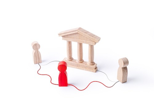 wooden people with red person connecting them in front of court