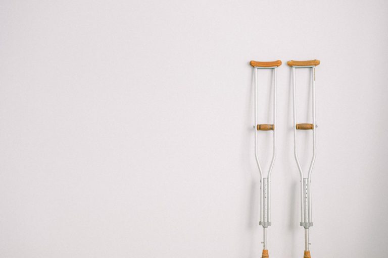 crutches against a plain white wall