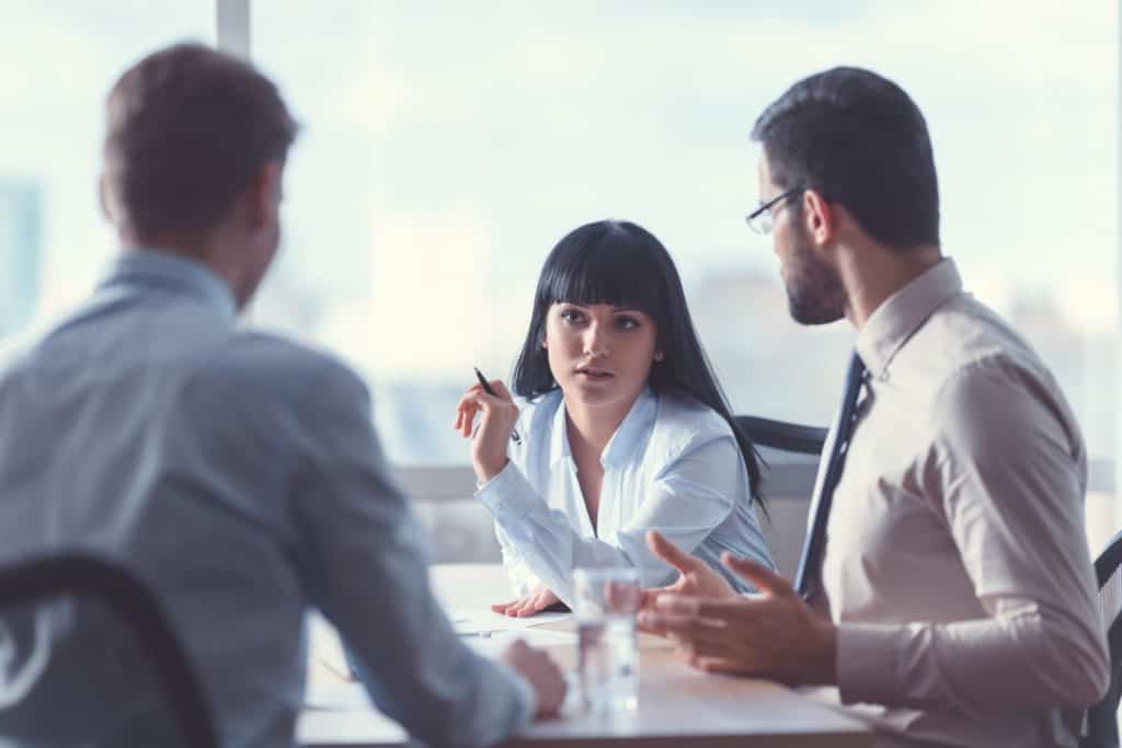 three business workers chatting in a meeting