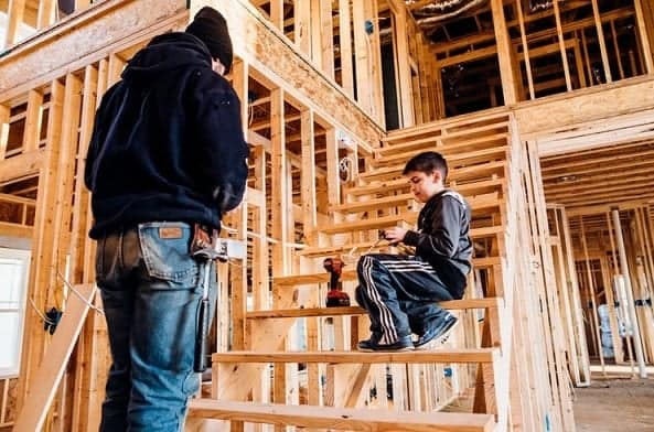 man and young boy sitting on stairs of construction site