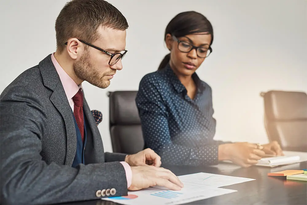 business man and woman looking over documents in meeting