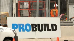A worker is standing next to a sign that says Probuild Administration.