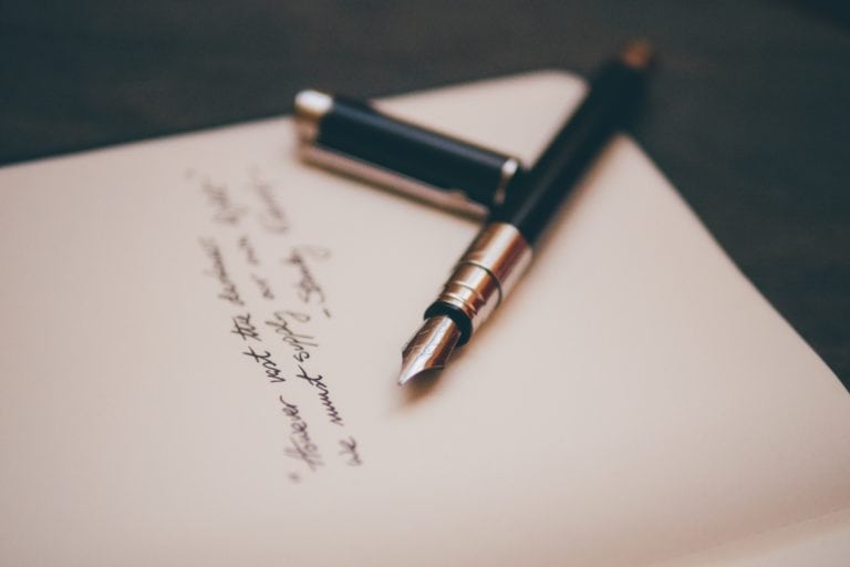 A fountain pen rests on top of an open notebook as the testator's will is located.