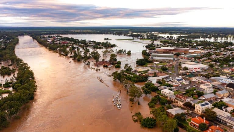 Aerial perspective showcasing flood damage in a town, prompting insurance claims.