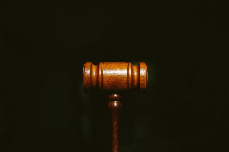 A wooden gavel on a dark background, representing a legal ruling concerning multiple supply charges.