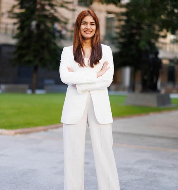 Based on the information provided, confident woman in white business attire standing with arms crossed.